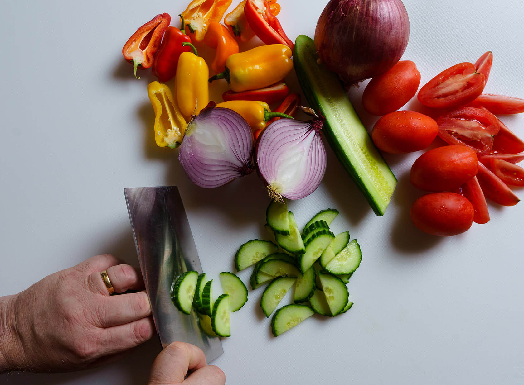 Man cutting up assorted vegetables